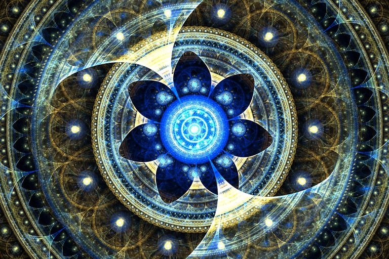 Intricate blue and gold fractal art featuring a luminous turquoise circular center, symmetrical petal-like shapes, and elaborate cosmic patterns.